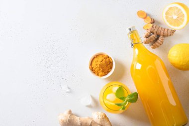 Jamu Endonezya bitkisel içeceği doğal malzemeli zerdeçal, beyaz üzerine zencefil. Mesaj için yer var. Yukarıdan görüntüle.