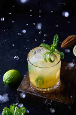 Taze Mai Tai romu kokteyli, üzerine su sıçratın ve siyaha damlatın. Dikey biçim.