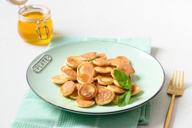 Ev yapımı küçük mısır gevreği krepleri nane şekerli ve beyaz masada bal var. Kapat..