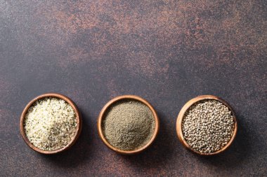 Kenevir tohumu, un, kahverengi üç kâse içinde çekirdekler. Süper manzara. Temiz yemek ve vegan için sağlıklı malzemeler. Boşluğu kopyala.