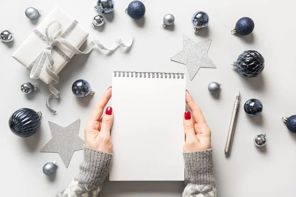 Vacío de Navidad en blanco para invitación en manos de mujer. Navidad. Vista desde arriba. Acostado. Planificación de gastos de regalo . —  Fotos de Stock