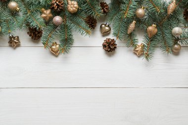 Altın takılar ve ahşap tahtada yeşil köknar ağacından yapılmış Noel beyaz çerçevesi. Üst görünüm.