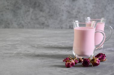 Gül ay sütü ve gri üzerine kuru güller. Boşluğu kopyala.