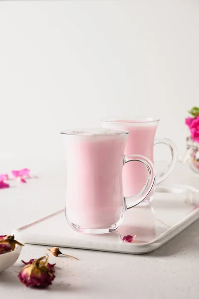 Rose moon milk in glasses for sleep on white background. Close up