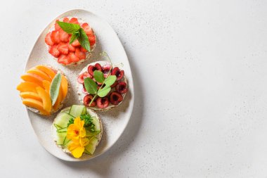 Beyaz arka planda farklı soslu pirinç kekleri ve sebzeler, düz yatak. Metin için boşluk.