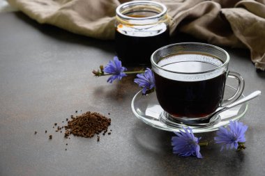 Cam bardakta hindiba, konsantre ve çiçekler. Sağlıklı bitkisel içecek, kahve yerine. Ön manzara. Kapatın. Boşluğu kopyala.