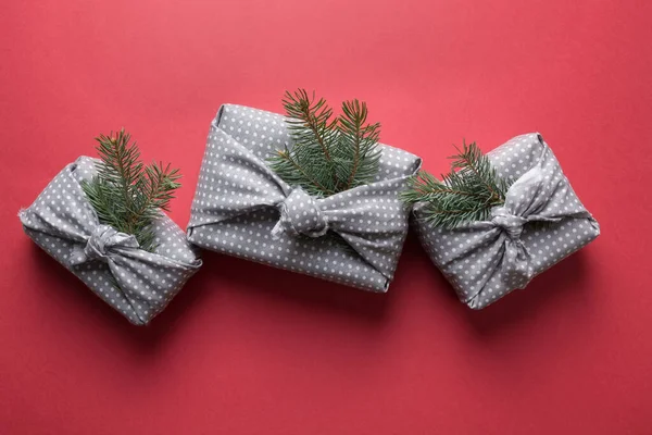 クリスマスの持続可能なギフトは赤い背景の灰色の繊維で包まれる 日本の風呂敷スタイル 上からの眺め — ストック写真