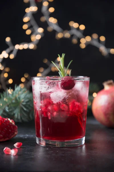 スパークリングワインとザクロクリスマスカクテルは ガーランドと休日の暗い背景にローズマリーの小枝を飾る 閉めろ — ストック写真