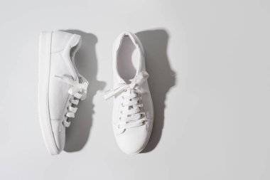 Gri arka planda beyaz kadın ayakkabıları. Yıkama konsepti. Spor ayakkabıları hakkında düzenli bakım.