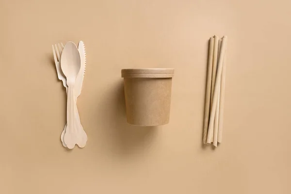 Eco-friendly biodegradable disposable cups and individual spoons, forks, bamboo straws on beige background. Sustainable lifestyle. Zero waste.