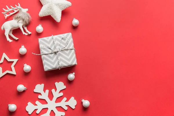 크리스마스의 하얀 장식, 선물, 바우 블, 사슴, 눈 자국이 붉은 배경에 있다. 위에서 바라본 평평 한 모습. — 스톡 사진