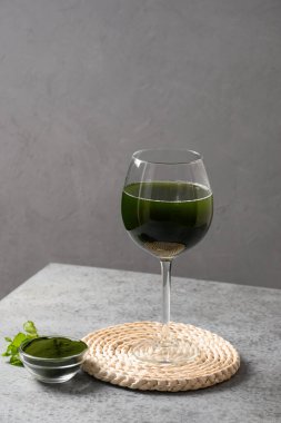 Klorella sağlıklı dezenfekte içeceği ve gri arka planda limon. Kapat..