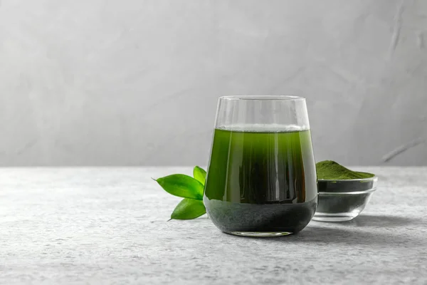 小球藻健康的排毒饮料在玻璃杯中 粉末在灰色背景的碗中 靠近点设计空间 — 图库照片