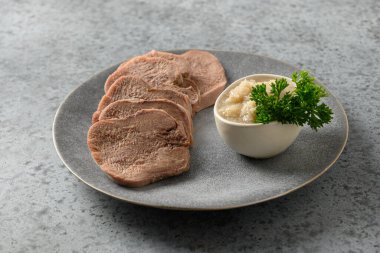 Gri üzerine yabanturpu sosu ile dilimlenmiş sığır dili. Sulu taze et harika bir aperatif. Kapat..