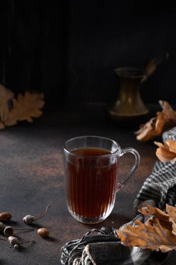 Cam bardakta meşe yapraklı meşe palamudu ve kahverengi fular. Kafeinsiz kahvenin yerine. Kapatın. Dikey biçim.