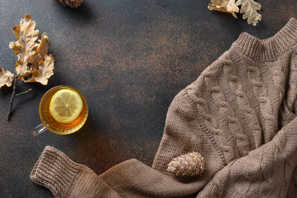 Теплый чай с лимоном в уютном свитере на коричневом. Вид сверху с пространством для копирования. — стоковое фото