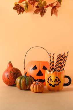 Cadılar Bayramı parti süslemeleri, şeker kasesi, balkabağı, tatlılar, turuncu arka planda yıldızlı bardak. Kopya alanı ile dikey bileşim.