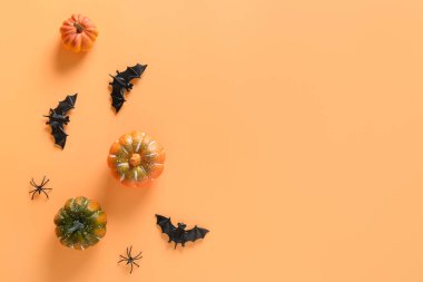 Cadılar Bayramı parti dekorasyonları, balkabakları, yarasa, turuncu arka planda ürkütücü örümcekler. Genel manzara, düz yatış. Boşluğu kopyala.