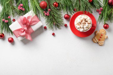 Noel tatili sınırında hediyeler, kahve, zencefilli ekmek, beyaz arka planda hep yeşil dallar. Fotokopi alanı olan Noel tebrik kartı. Üst manzara, düz uzanma.