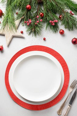Beyaz masa üzerinde beyaz ve kırmızı zarif süslemeleri olan bir Noel masası. Yukarıdan bak. Dikey biçim.