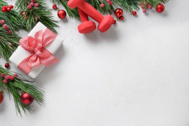 Kırmızı halterli Noel kompozisyonu ve beyaza hediye. Kopyalama alanı olan arkaplan Üst manzara, düz yatış. Fitness, spor ve sağlıklı yaşam şablonu.