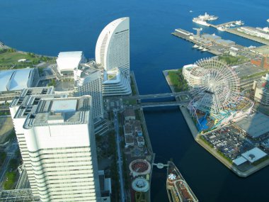 Yokohama şehrinin merkezi ticaret bölgesi Minato Mirai 21 'in kıyı şeridinden panoramik manzara. Tokyo Körfezi' nin güneşli bir gününde modern yüksek binalar, Kanagawa Bölgesi, Japonya.  