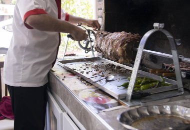 Şef İstanbul'da açık bir restoranda geleneksel türk cag kebabı hazırlar.Cag kebabı döner kebap gibi görünür, ama ateşin önüne yatay olarak konur