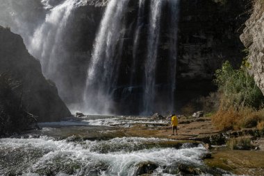 Türkiye 'deki Tortum Şelalesi' ne bakan maceraperest. Türkiye 'deki Tortum şelalesinde dinlenen sarı ceketli bir turist. Türkiye 'nin Erzurum kentindeki Tortum Şelalesinin manzara görüntüsü