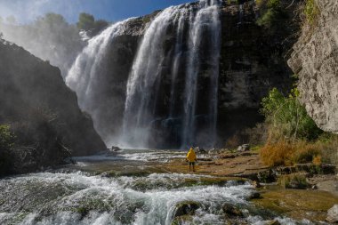 Türkiye 'deki Tortum Şelalesi' ne bakan maceraperest. Türkiye 'deki Tortum şelalesinde dinlenen sarı ceketli bir turist. Türkiye 'nin Erzurum kentindeki Tortum Şelalesinin manzara görüntüsü