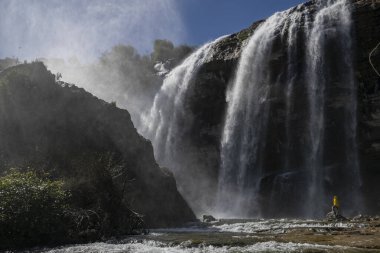 Türkiye 'deki Tortum Şelalesi' ne bakan maceraperest. Türkiye 'deki Tortum şelalesinde dinlenen sarı ceketli bir turist. Türkiye 'nin Erzurum kentindeki Tortum Şelalesinin manzara görüntüsü