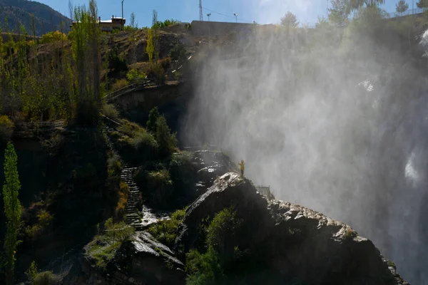 Man standing on a rock near a big waterfall. Explore the world's beauty and wildlife. Landscape view of Tortum Waterfall in Erzurum,Turkey