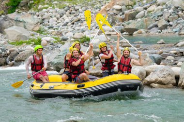 Rize, TURKEY - 30 Temmuz 2016: Gün batımında veya gün doğumunda rafting yaptıktan sonra kutlama yapan mutlu insanlar grubu.
