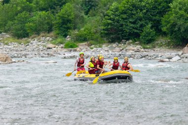 Rize, TURKEY - 30 Temmuz 2016: Gün batımında veya gün doğumunda rafting yaptıktan sonra kutlama yapan mutlu insanlar grubu.