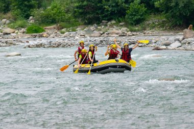 Rize, TURKEY - 30 Temmuz 2016: Gün batımında veya gün doğumunda rafting yaptıktan sonra kutlama yapan mutlu insanlar grubu.