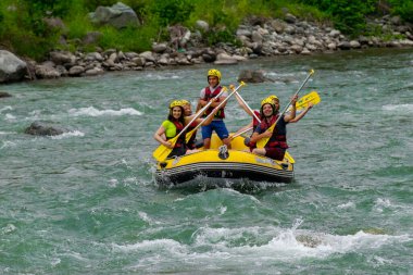 Rize, TURKEY - 30 Temmuz 2016: Gün batımında veya gün doğumunda rafting yaptıktan sonra kutlama yapan mutlu insanlar grubu.