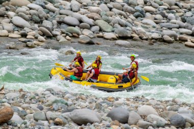 Kaba bir akıntıda rafting yaparken kayıktaki insan grupları, Türkiye 'nin Rize kentinde bir dağ nehrinde akın ediyor.
