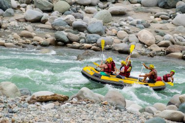 Kaba bir akıntıda rafting yaparken kayıktaki insan grupları, Türkiye 'nin Rize kentinde bir dağ nehrinde akın ediyor.