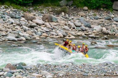Kaba bir akıntıda rafting yaparken kayıktaki insan grupları, Türkiye 'nin Rize kentinde bir dağ nehrinde akın ediyor.