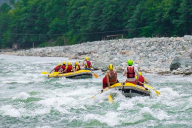 Kaba bir akıntıda rafting yaparken kayıktaki insan grupları, Türkiye 'nin Rize kentinde bir dağ nehrinde akın ediyor.