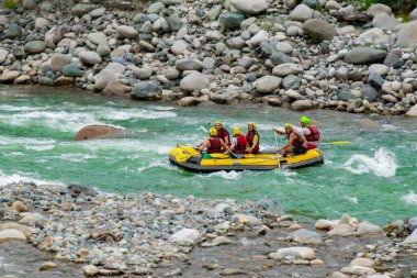 Kaba bir akıntıda rafting yaparken kayıktaki insan grupları, Türkiye 'nin Rize kentinde bir dağ nehrinde akın ediyor.