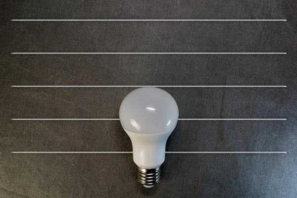 top view of LED light bulb on gray background with copy space, flat lay