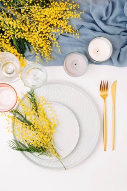 Festival Tablo ayarı. Tabak ve çatal bıçak takımı gri dekoratif Tekstil ve beyaz zemin üzerine sarı çiçekleri ile. Güzel aranjman.
