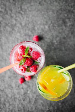 Salatalık ve taş masanın üstüne çilek limonata ile turuncu limonata