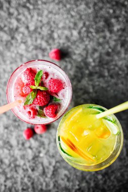 Salatalık ve taş masanın üstüne çilek limonata ile turuncu limonata