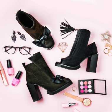 Soluk pembe bir arka plan üzerinde aksesuar ile şık kadın siyah ayak bileği botları. Düz yatıyordu, en iyi görünümü.