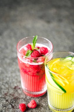 Salatalık ve taş masanın üstüne çilek limonata ile turuncu limonata