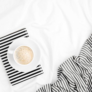 Kitap ve kahve Kupası ile yaprak yatak takımları. Düz yatıyordu, en iyi görünümü