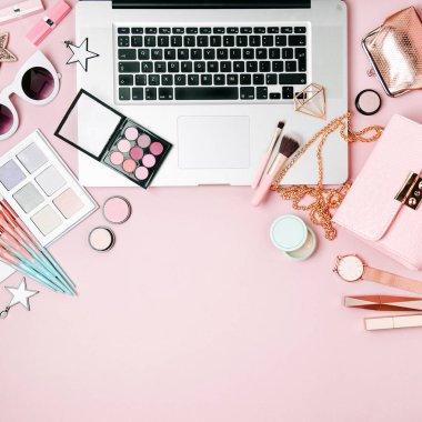 Moda blogger çalışma alanıyla soluk pembe tablo üzerinde laptop ve erkek Aksesuar, kozmetik ürünleri. düz yatıyordu, en iyi görünümü