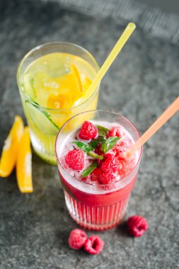 Salatalık ve taş masanın üstüne çilek limonata ile turuncu limonata