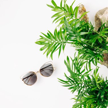 Tropikal yaprak ve metin için yer ile beyaz bir arka plan üzerinde güneş gözlüğü. Üstten Görünüm, düz yatıyordu.